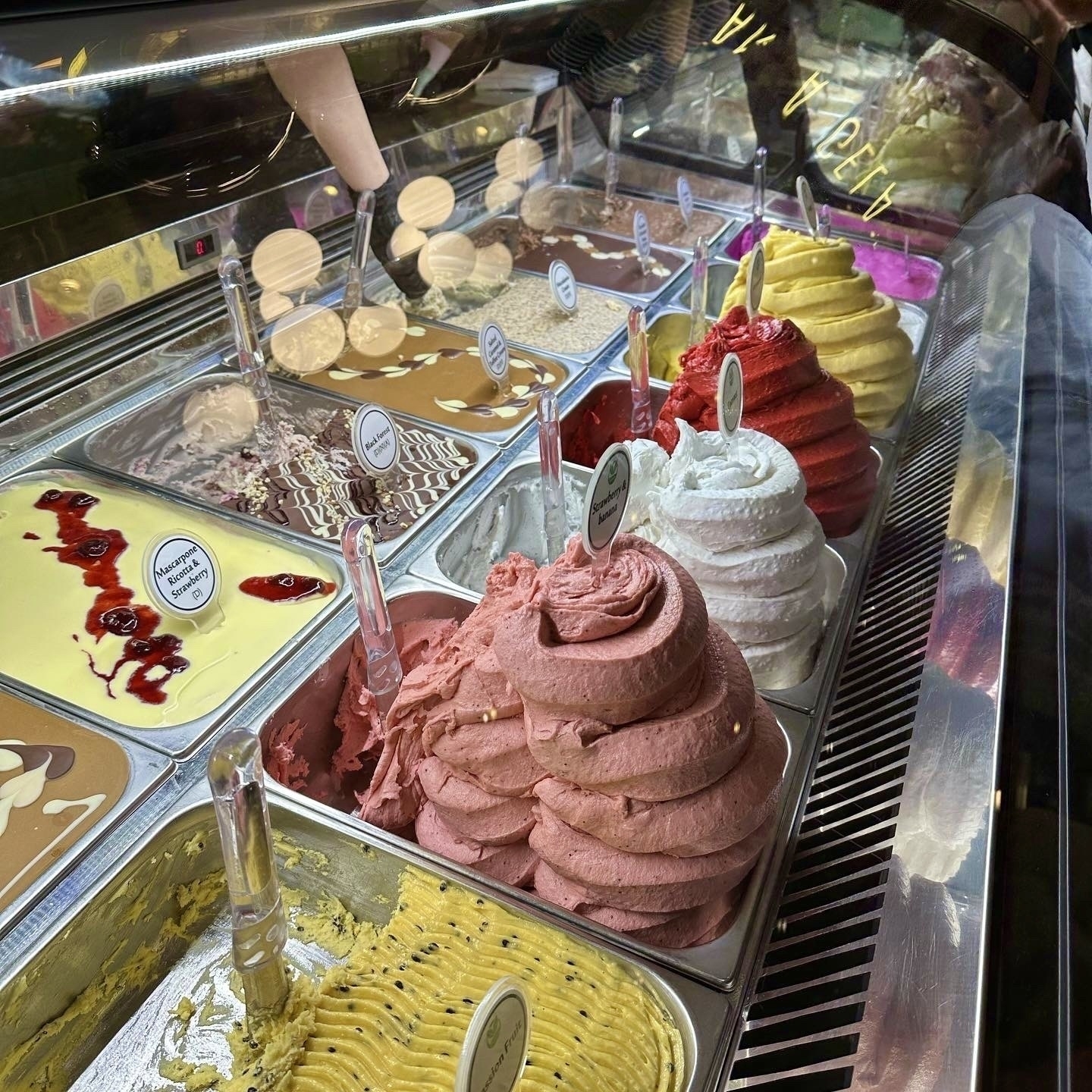 A variety of brightly coloured ice cream in a fridge cabinet. 