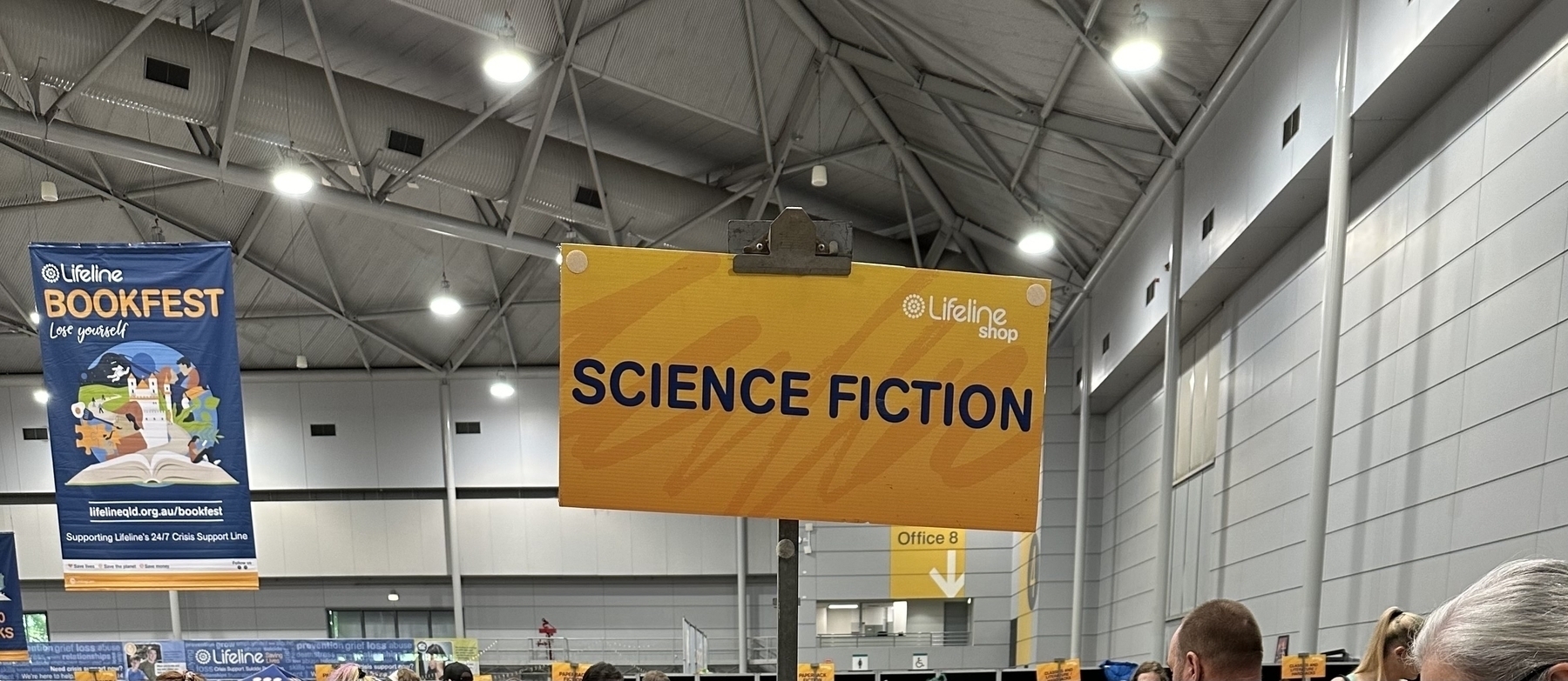 A rectangular yellow sign with “Science Fiction” in black capital letters on it.