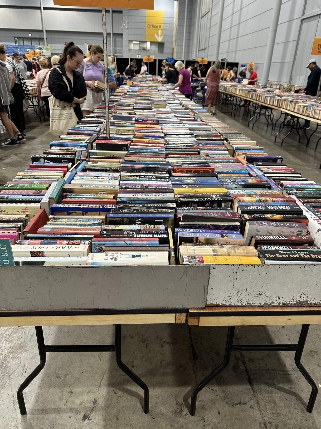 A long row of trestle tables stretching approximately 20m loaded with rows of second hand books.