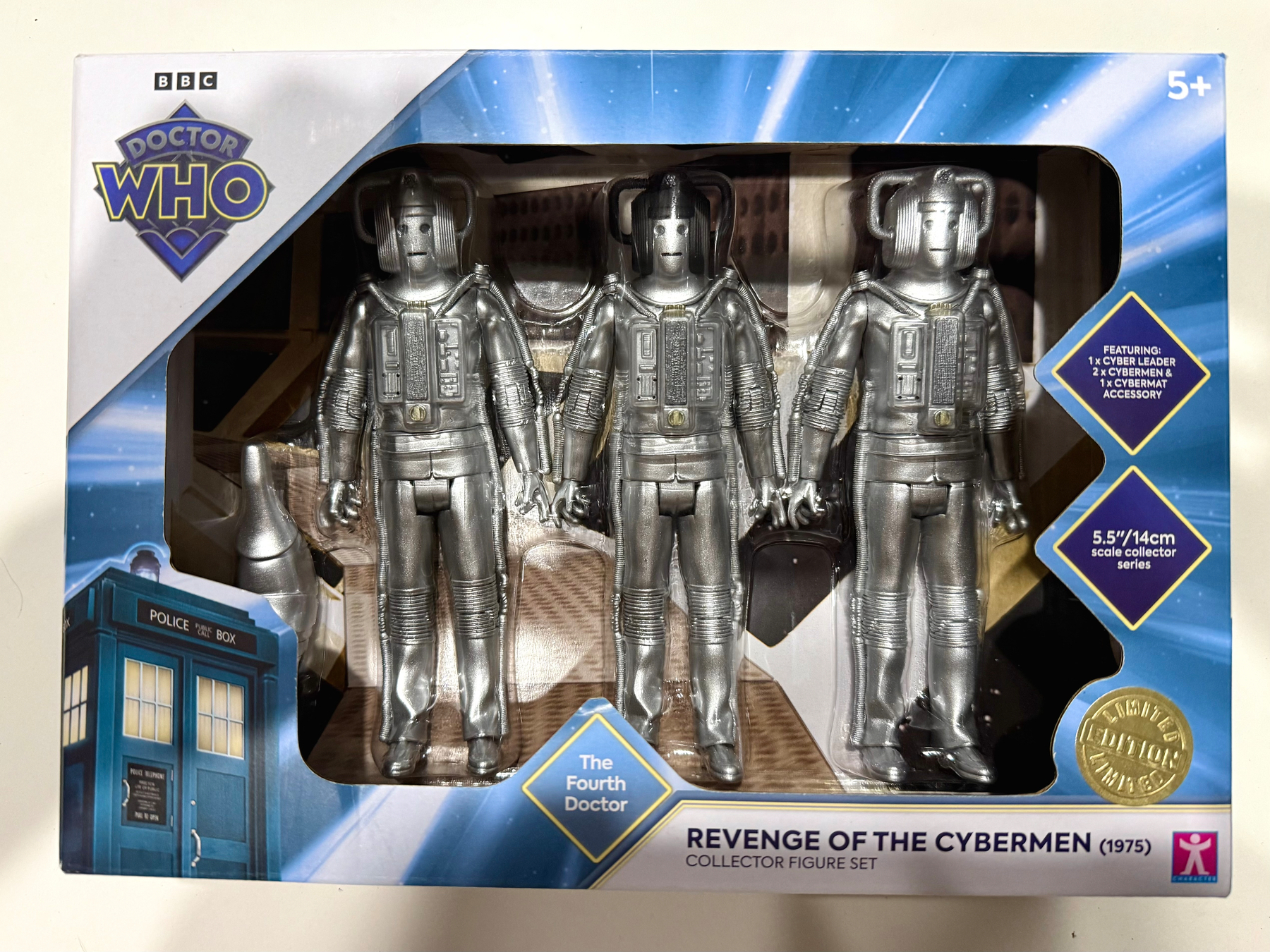 A rectangular box with a clear plastic window showing three silver cybermen and a cybermat inside it. The box has the BBC Doctor Who logo in the top left corner. Along the bottom is “The Fourth Doctor” and “Revenge of the Cybermen (1975) Collector Figure Set”. The bottom right corner has a gold “Limited Edition” and on the right hand side it indicates 5.5”/14cm scale.