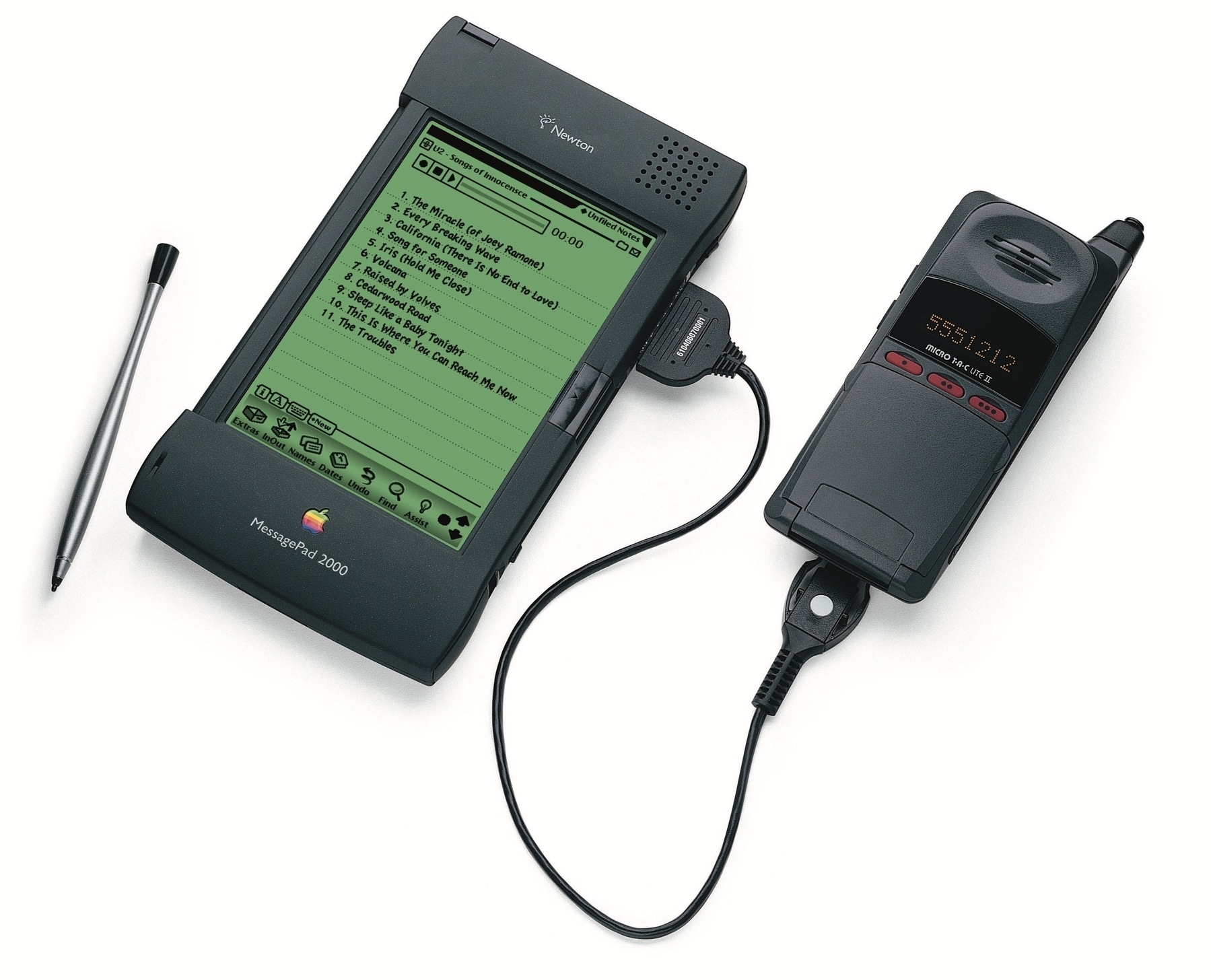 Newton MessagePad 2000 connected to a cell phone with a track listing for U2's Songs of Inocense on the display