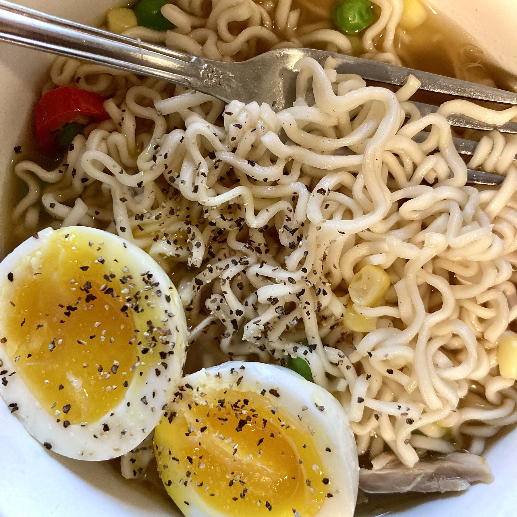 Bowl of instant ramen with soft boiled egg and veggies.