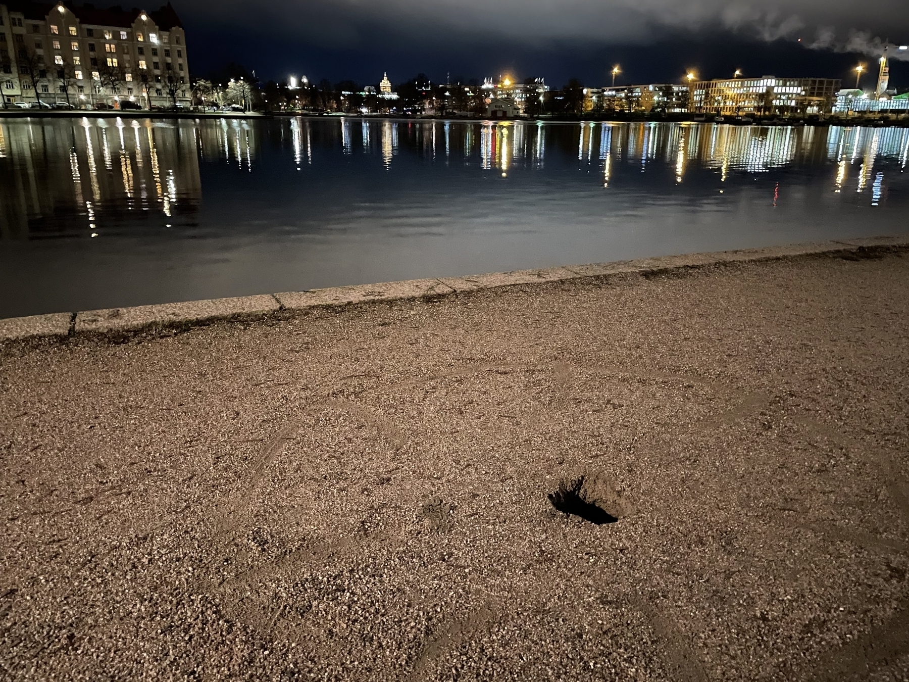 Tokoinranta, Helsinki at night, buildings reflected in water, small hole in the ground
