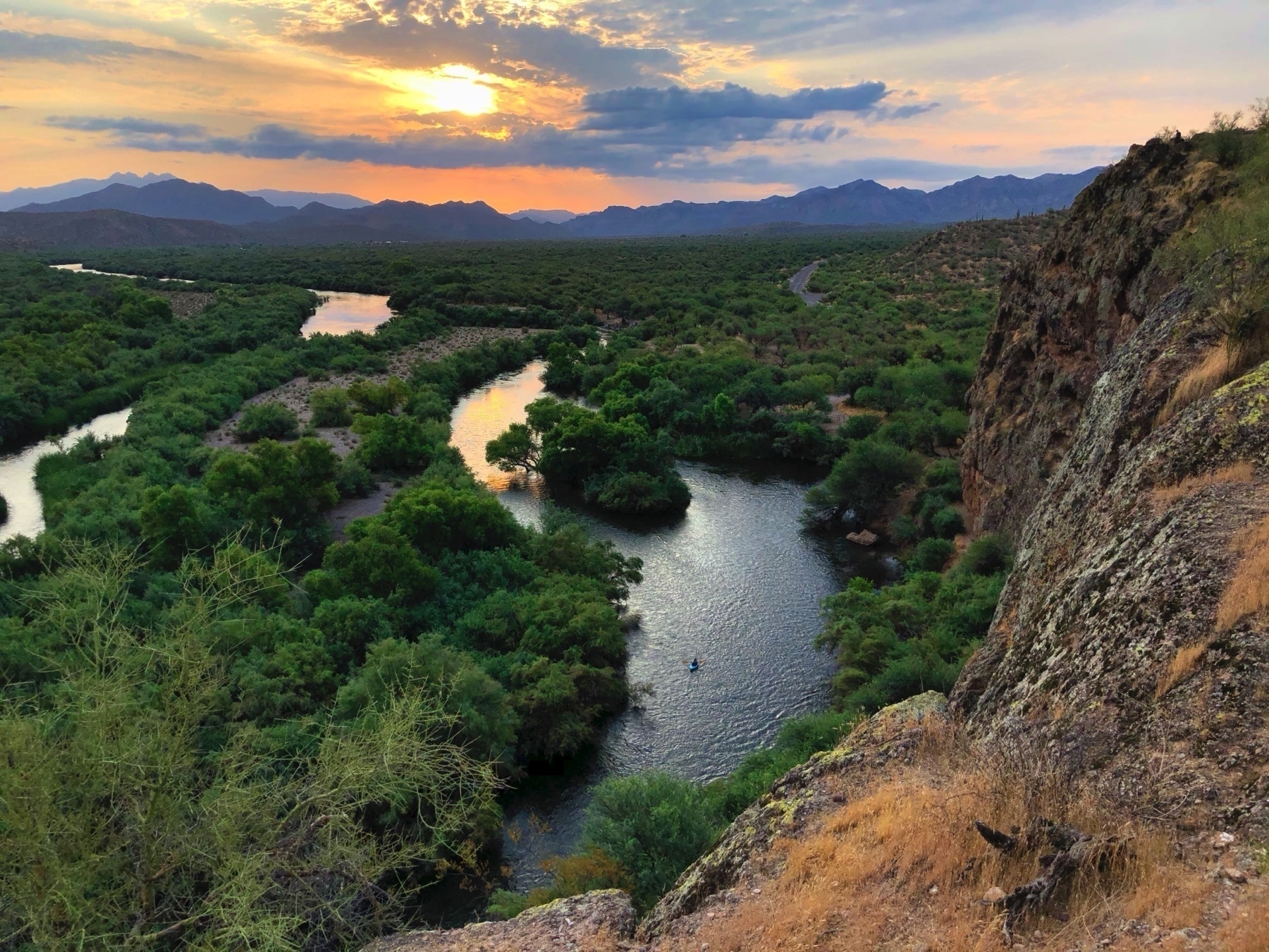 Kayaker in the river, viewed from cliff above