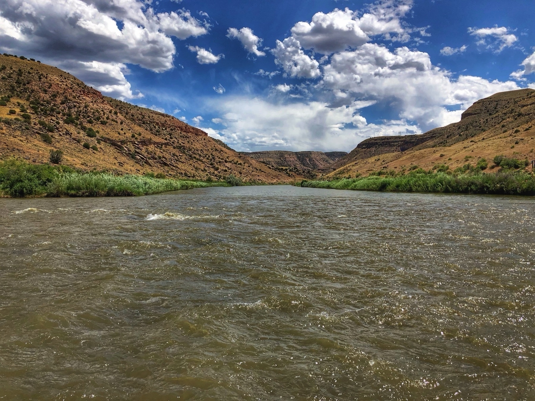 High desert river with nice clouds looking towards sloping valley