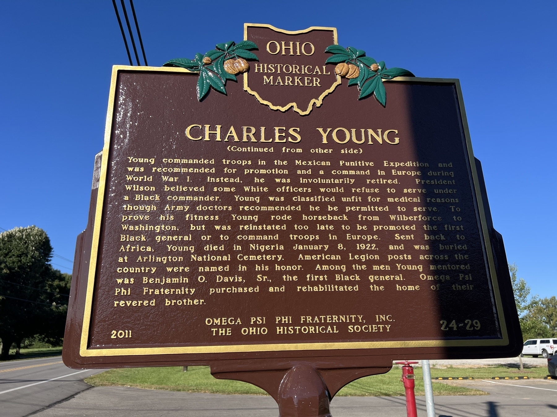 A historical marker for Charles Young is displayed against a clear blue sky.