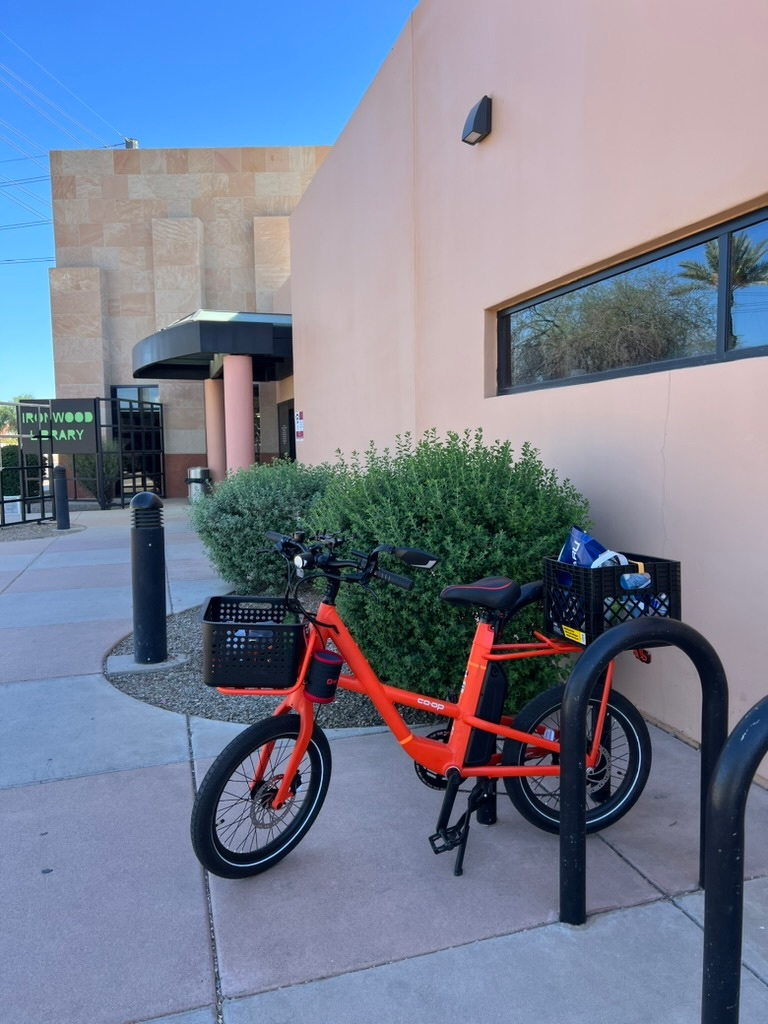 Orange ebike parked at a local public library branch.