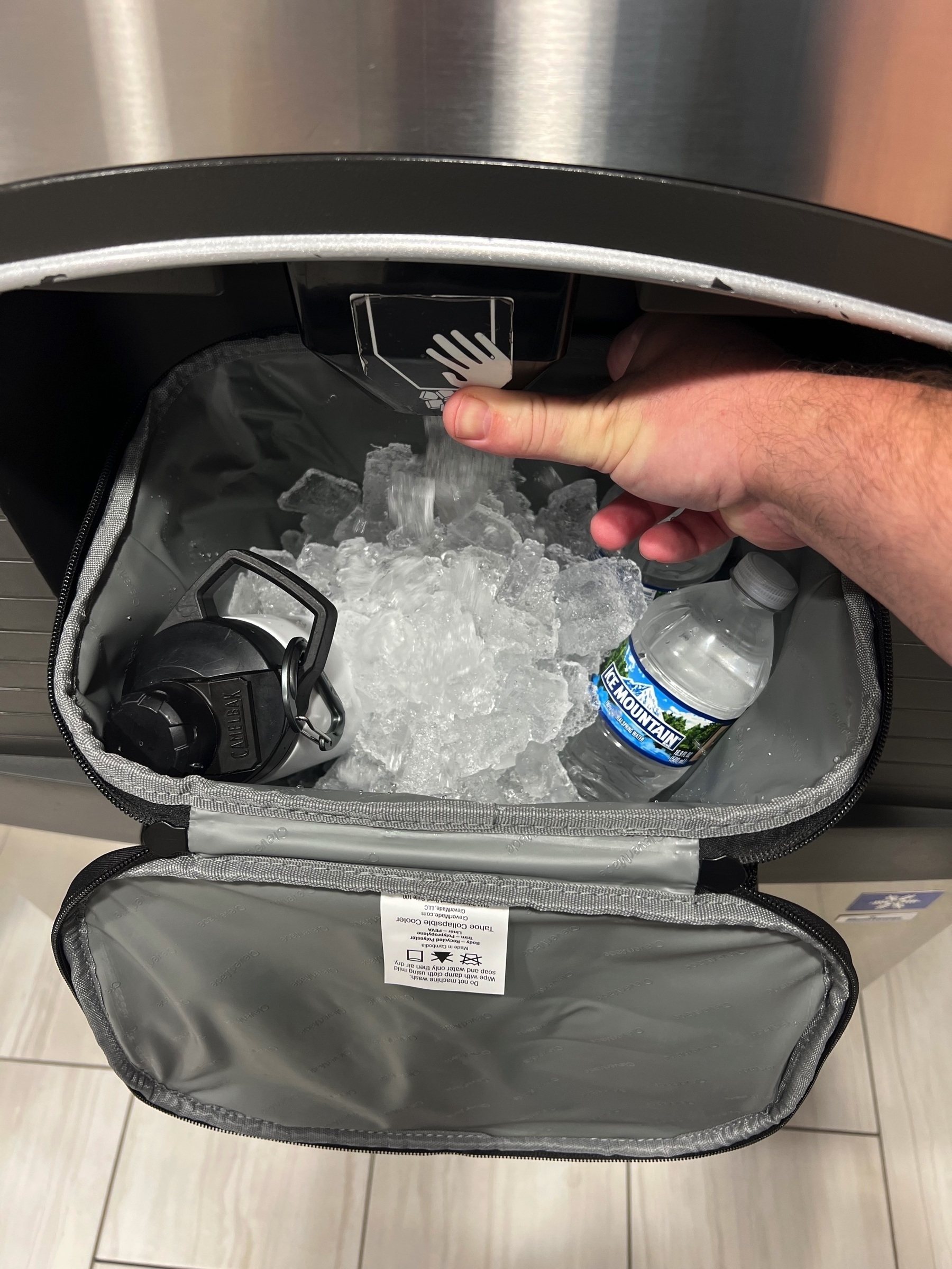 small cooler receiving an ice refill in one of those hotel ice machines.