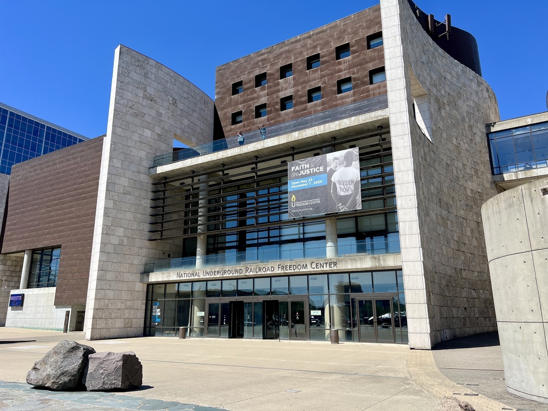 A modern building with large windows and curved stone walls houses the National Underground Railroad Freedom Center.