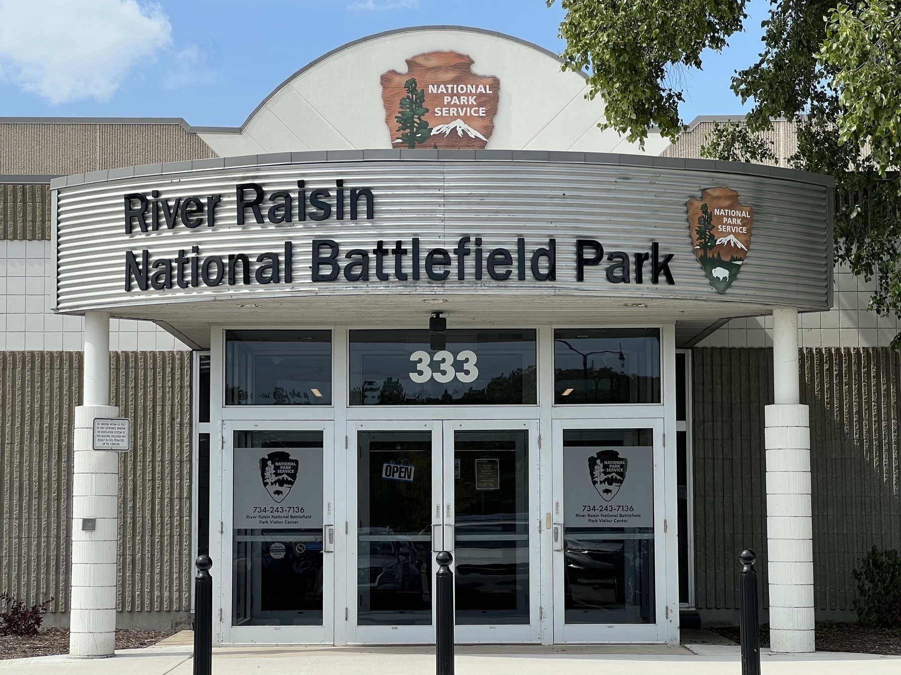 The entrance to River Raisin National Battlefield Park features signage and the National Park Service logo above its doors.