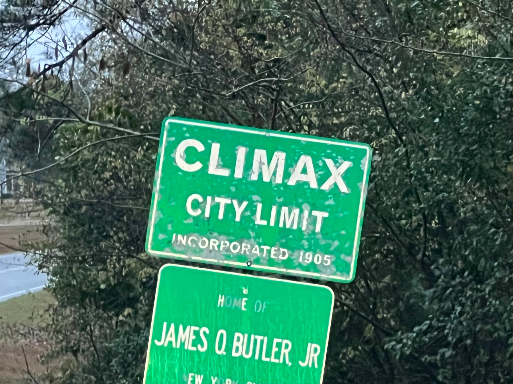 A brick sign with flowers and a red fire hydrant nearby welcomes visitors to Climax with a date marked 1905 below.