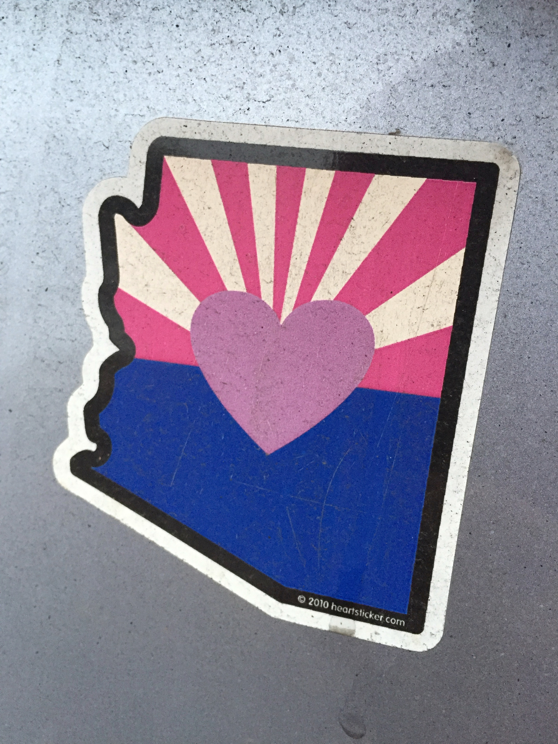 “I heart Arizona” stylized sticker on a vehicle depicting the Arizona state flag design inside a graphic of the state, replacing the star with a heart.