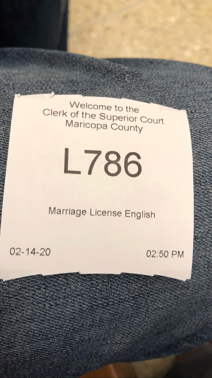 Auto-generated description: A ticket labeled L786 for a marriage license in Maricopa County, dated February 14, 2020, is placed on denim fabric.