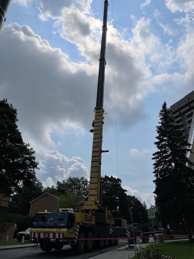 giant Guay crane extended into the sky, next to apartment block