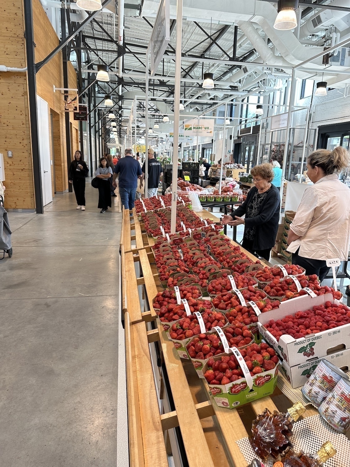 a stall covered in large punnets of strawberries and raspberries.