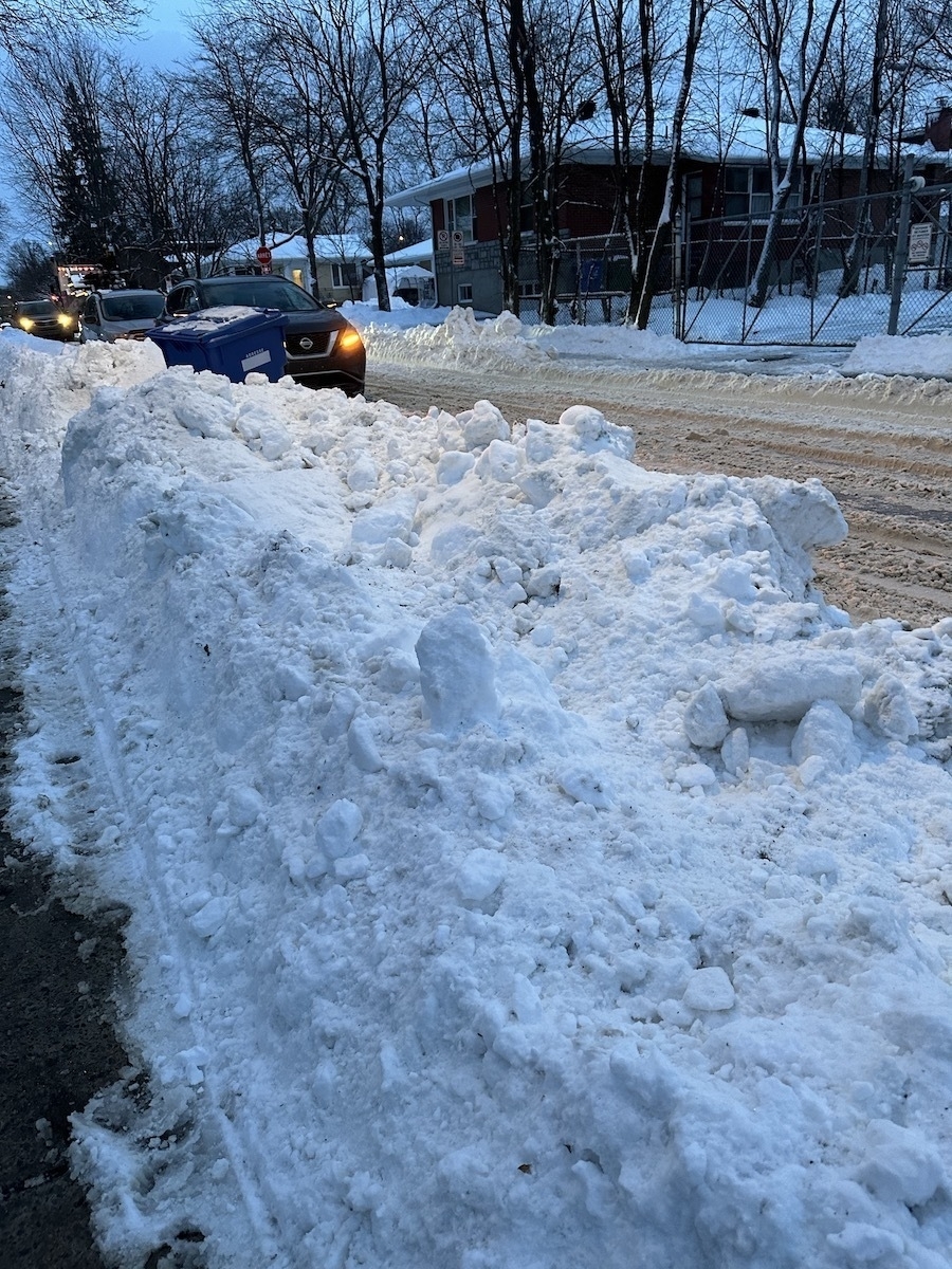 a snowbank adjoing the road, in the late evening 
