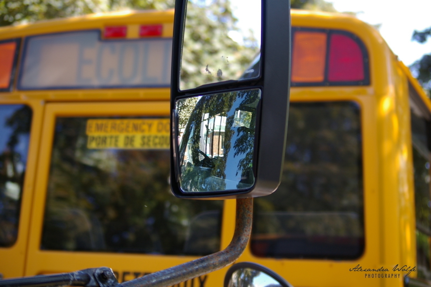 a reflective photo in the wing mirror of a school bus