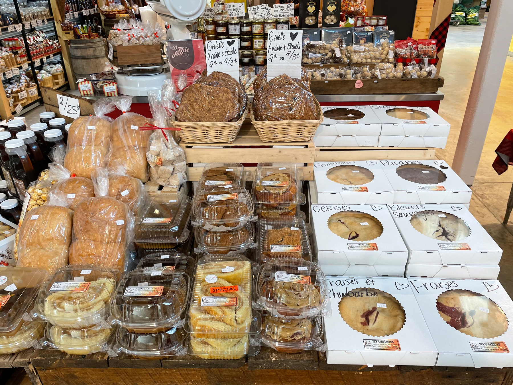 A bakery display showcases a variety of pastries, pies, and breads at a market.