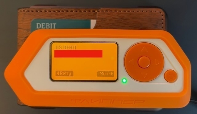 A Flipper Zero showing redacted credit card info.