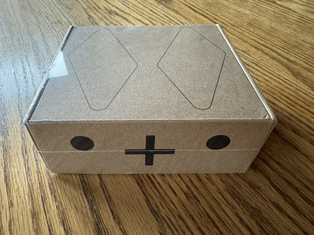 A cardboard box with diamonds on the top and º + º on the front so that it looks kind of like a bunny from the right angle.