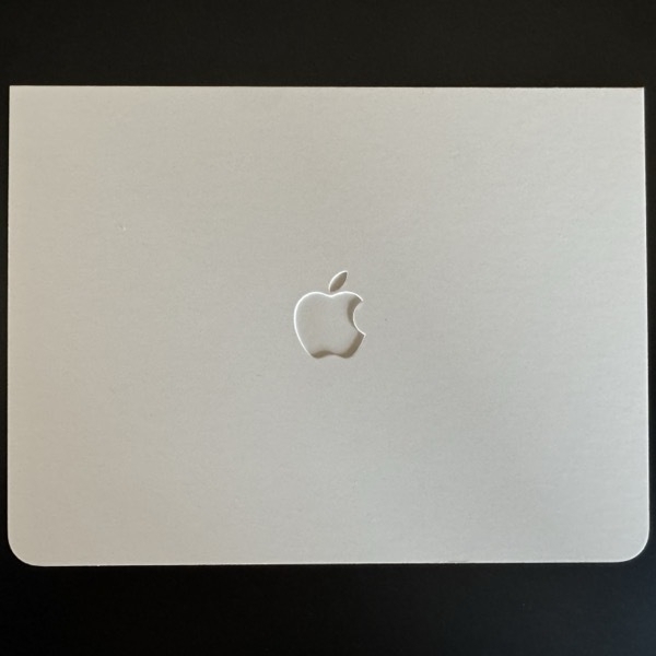 A slightly off-white heavy stock envelope with rounded corners and an embossed Apple logo.