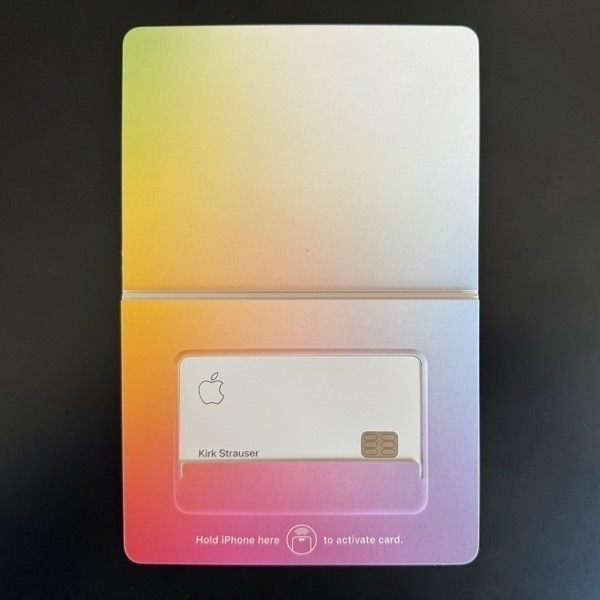 A rainbow-colored cardboard sleeve with a titanium credit card nestled inside a perfectly-sized cutout.