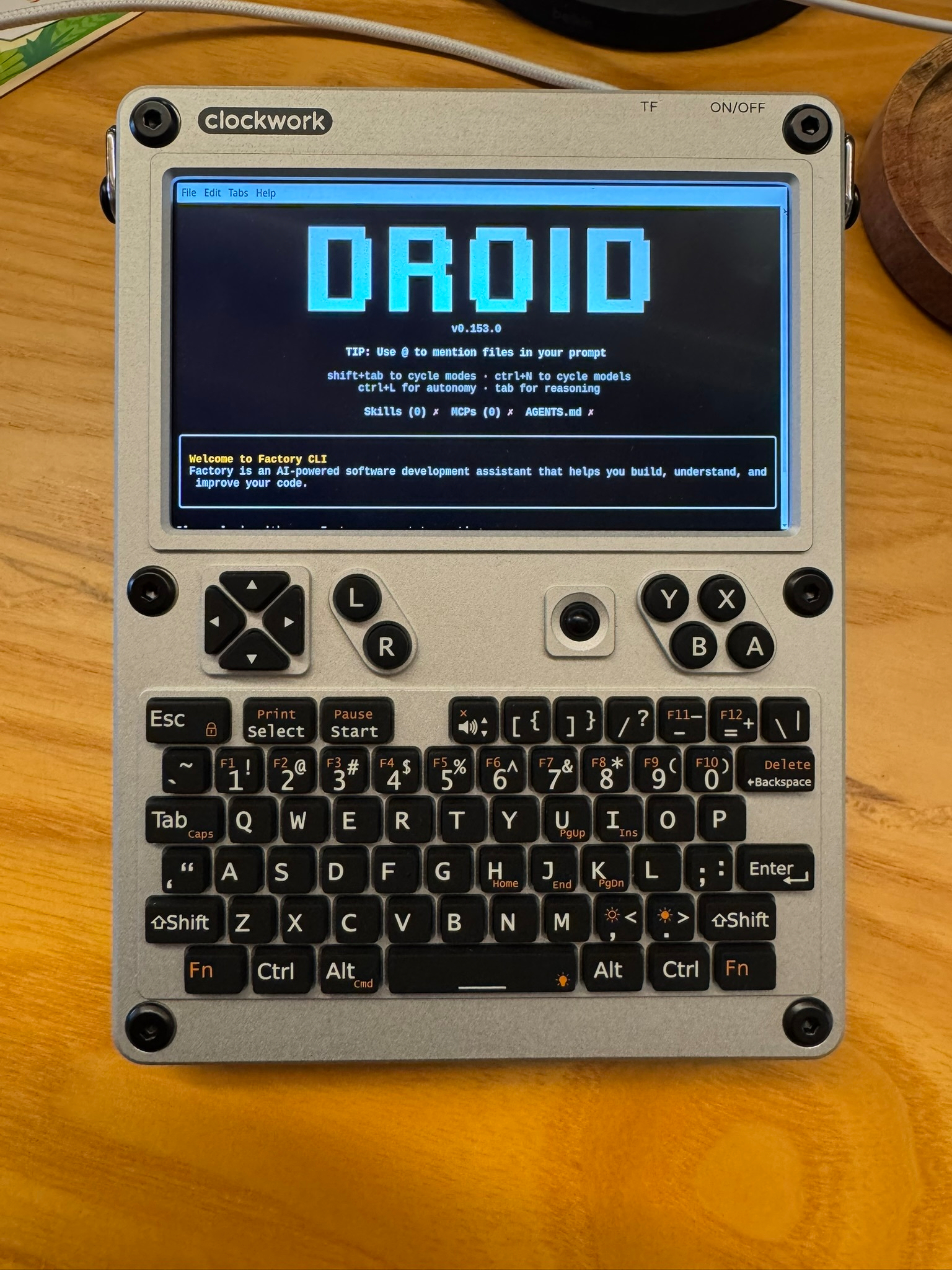 Photo of a uConsole handheld computer displaying the Droid text logo in a terminal window.