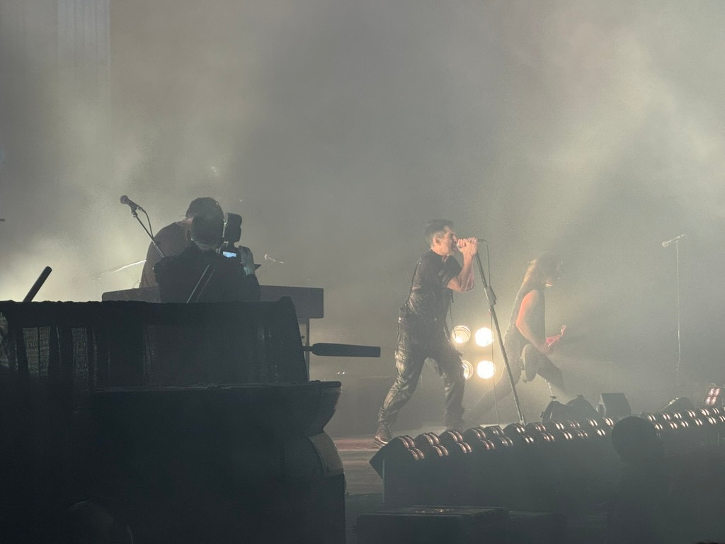 Side view of Nine Inch Nails on stage, from about 30 feet away.