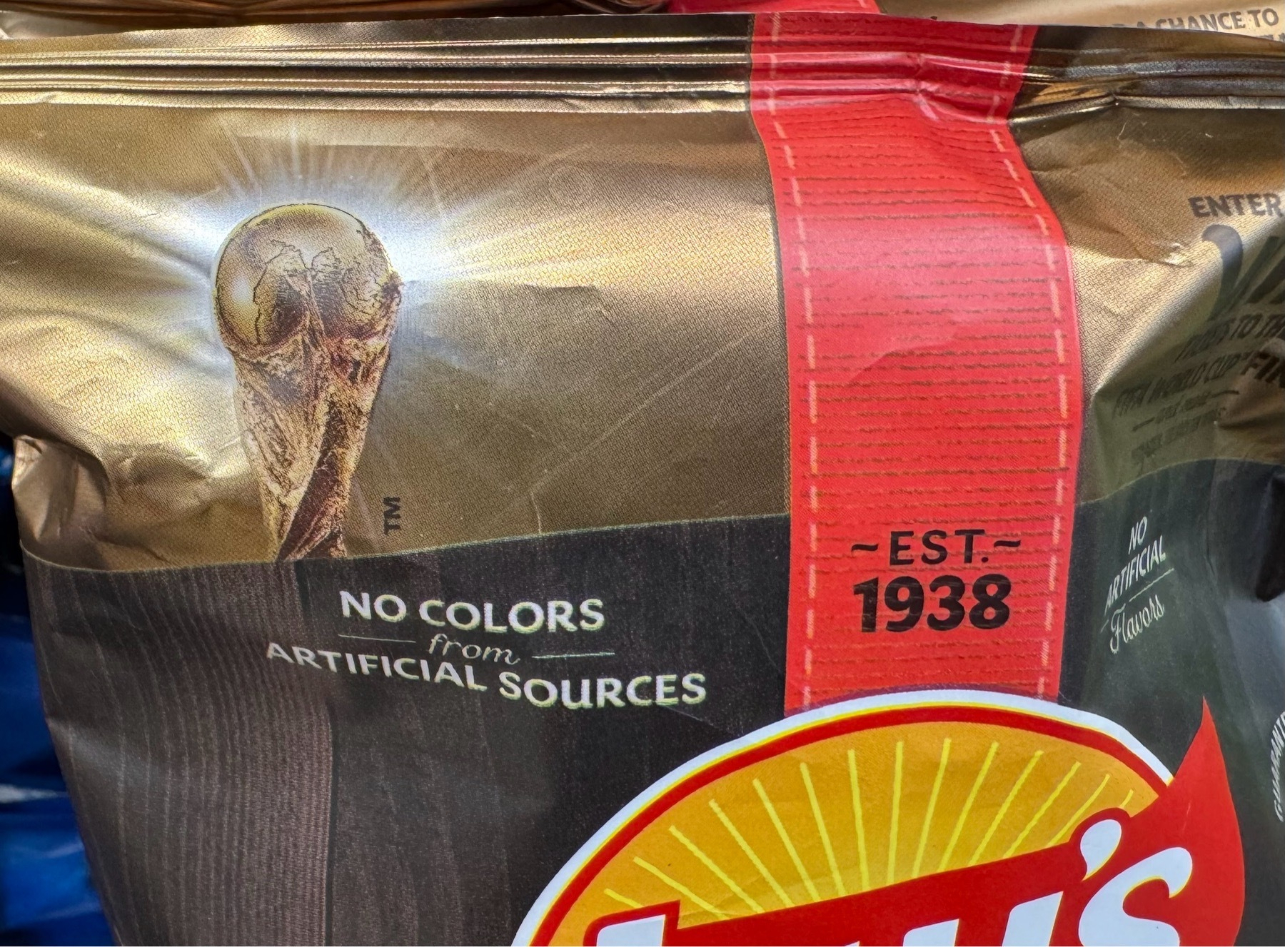 Photo of a potato chip bag with what I presume is a World Cup trophy. That logo is angled such that it looks like a gold plated Alien with a gaping mouth and no chin.