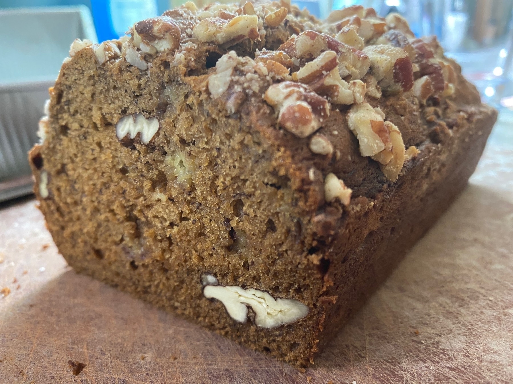 A loaf of banana bread with pecans on top