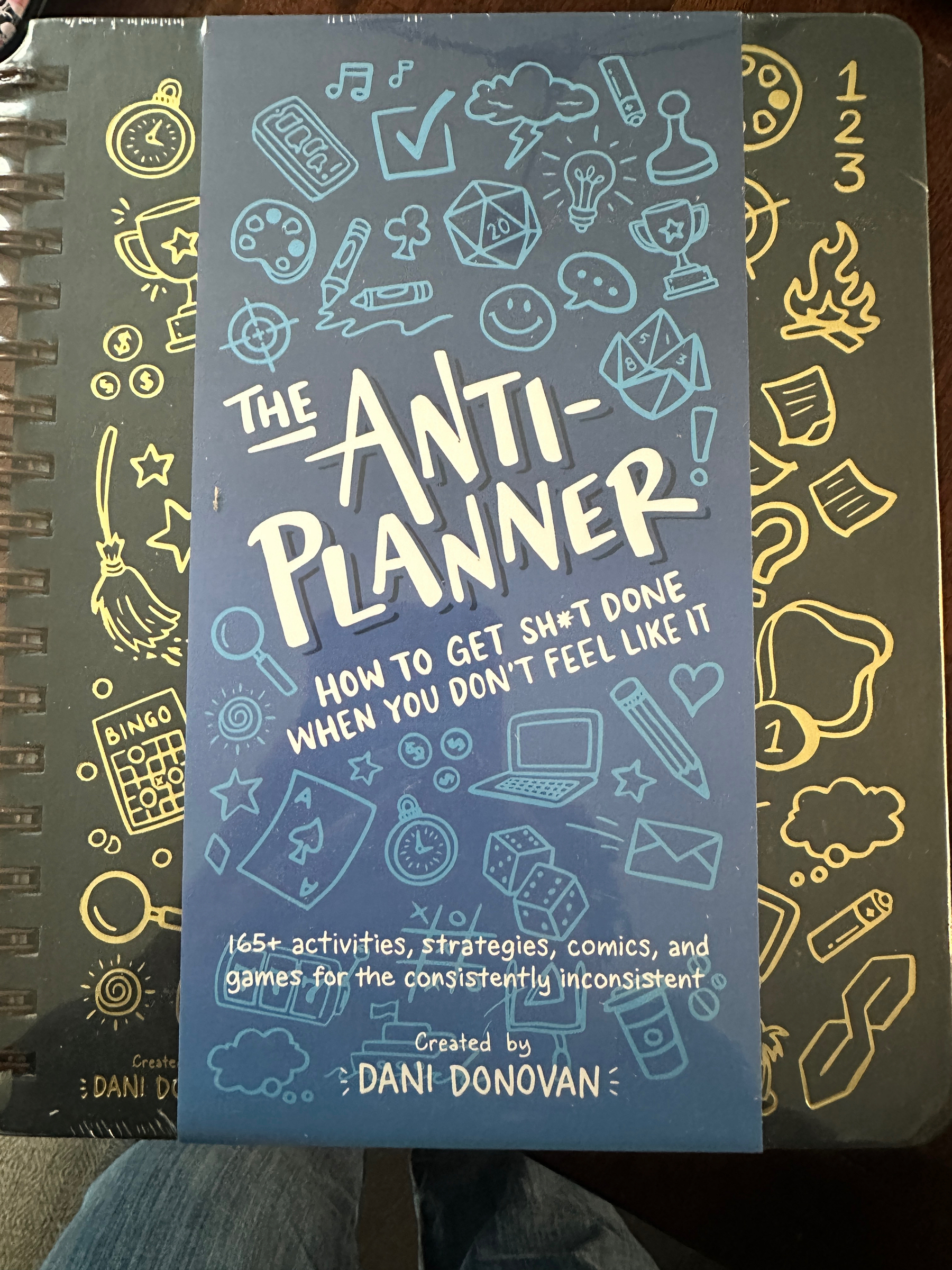 Very large activity book for procrastinators and those with ADHD The Anti-Planner: How to Get Sh!t Done When You Don’t Feel Like It. Created by Dani Donovan
