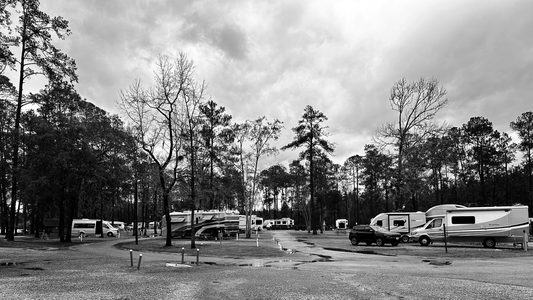 A black and white photo of an RV park with no humans in sight. 