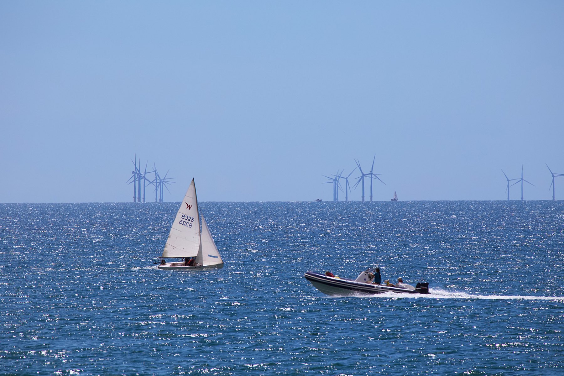 Various boats off Shoreham Beach, with Rampion wind farm on the horizon. 