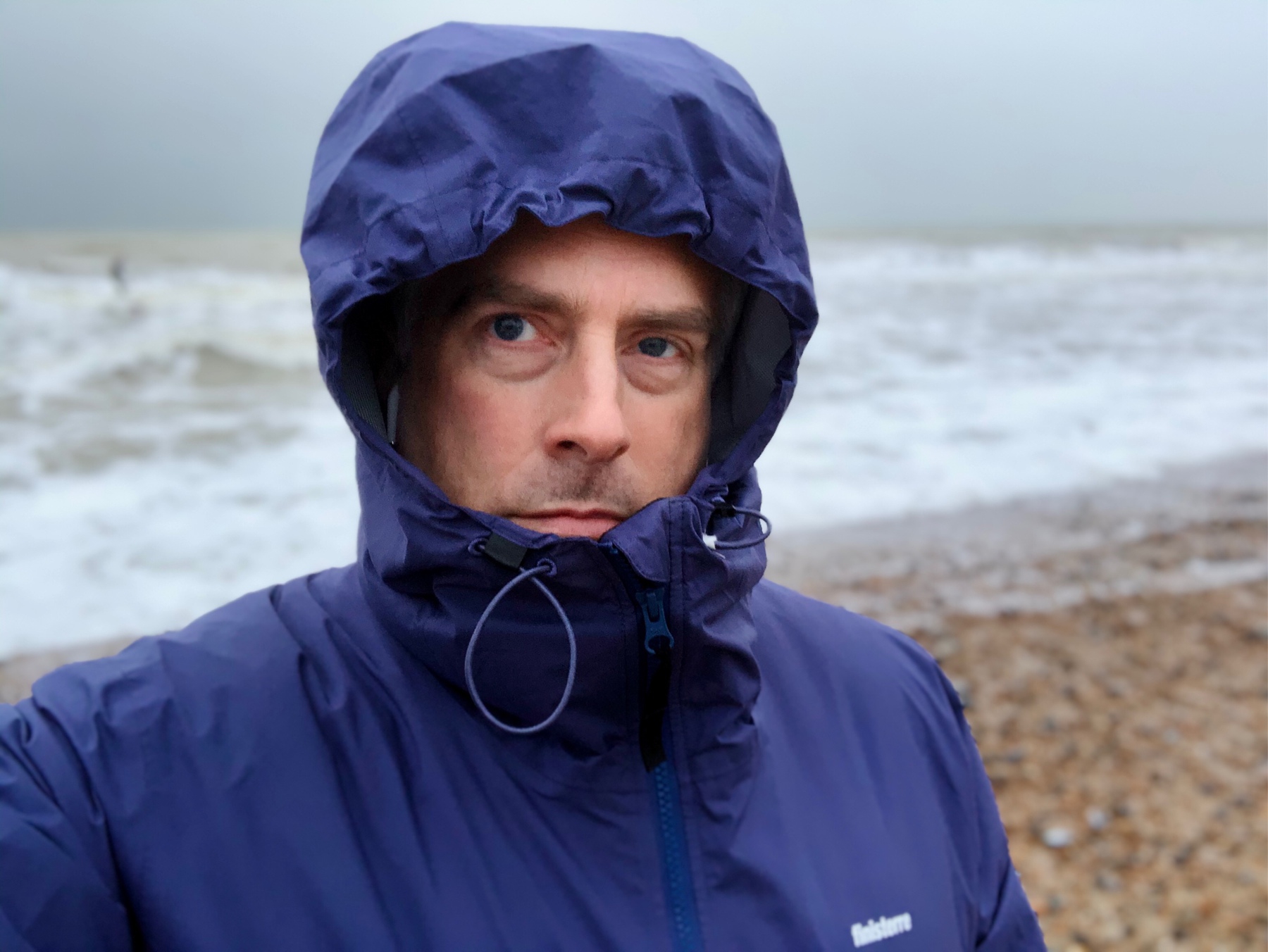 Adam Tinworth in a raincoat on Shoreham Beach.