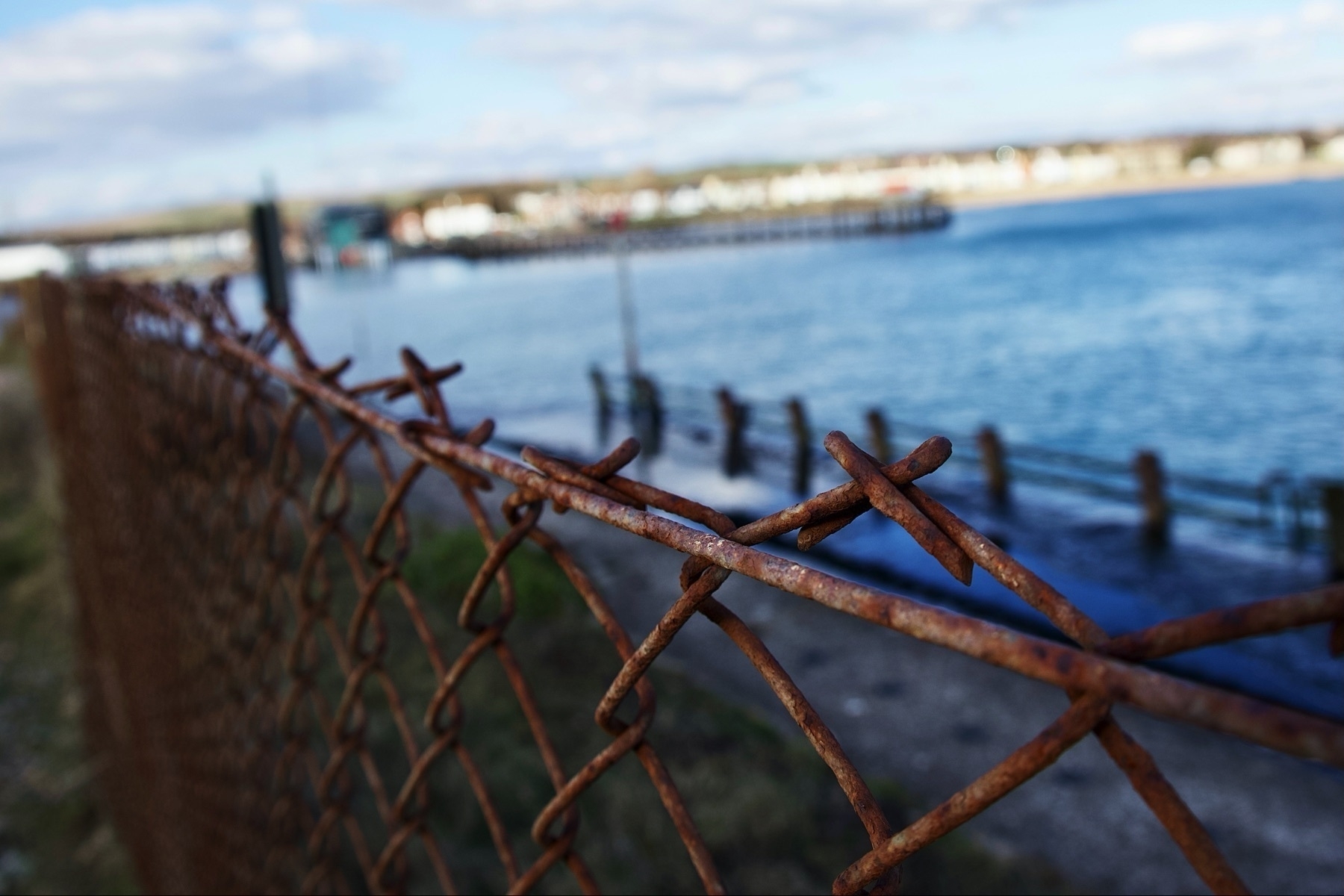A barbed wire fence blocking access to the water’s edge on Shoreham Beach. 
