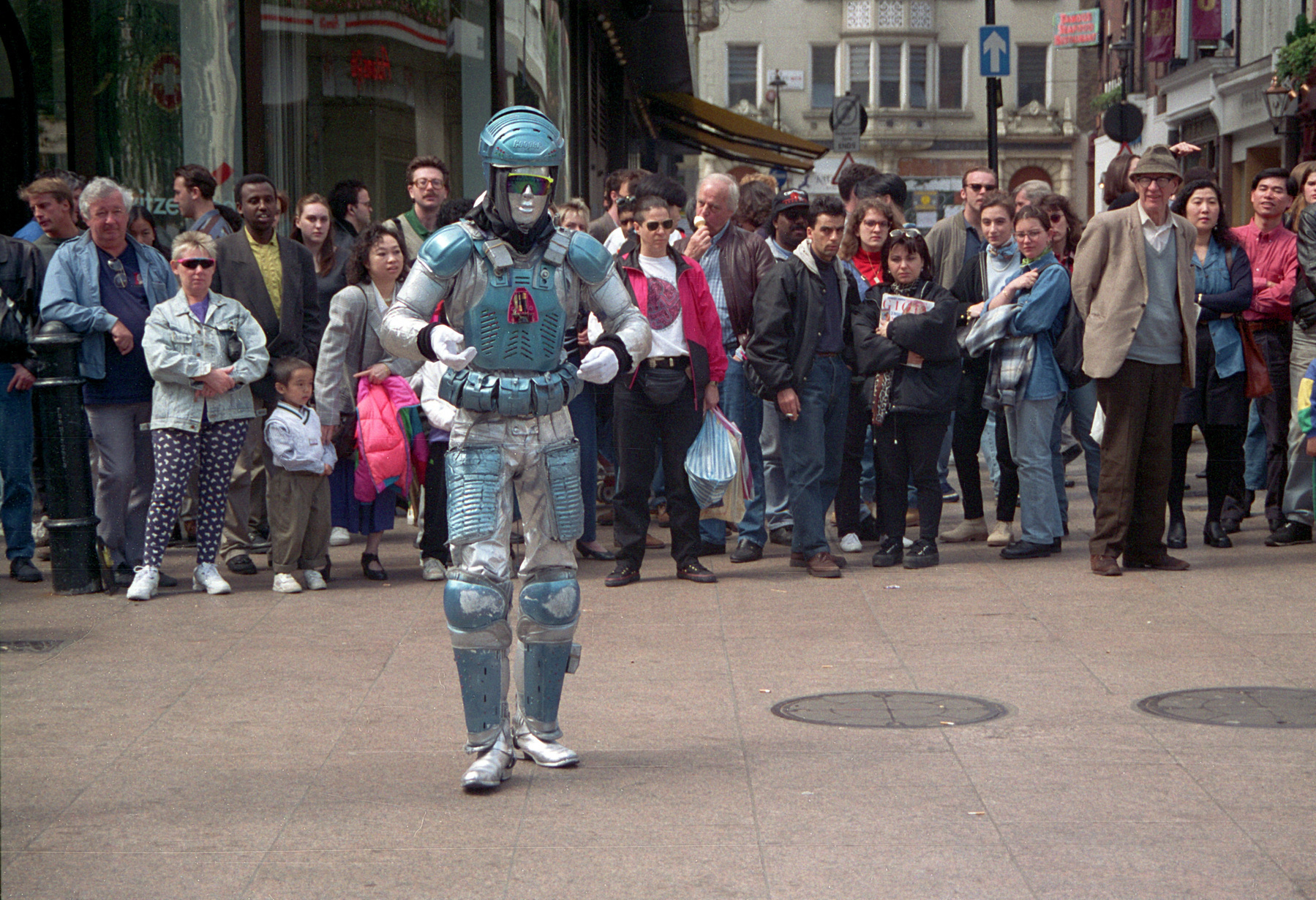 A robot busker near Leicester Square in 1994, being watched by a crowd of tourists.