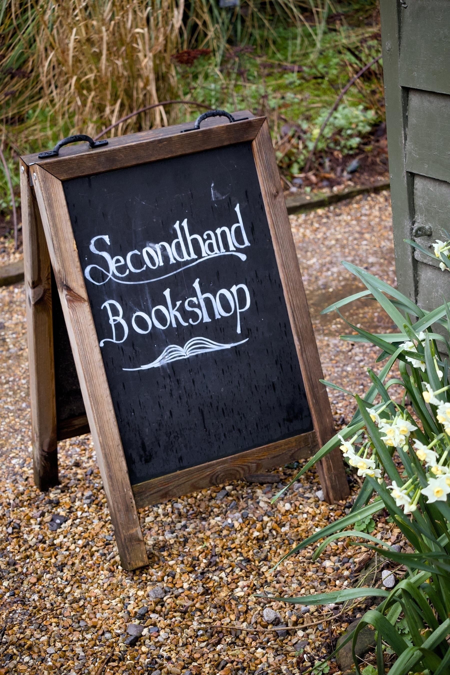 An a-frame backboard with “secondhand bookshop” written in chalk.