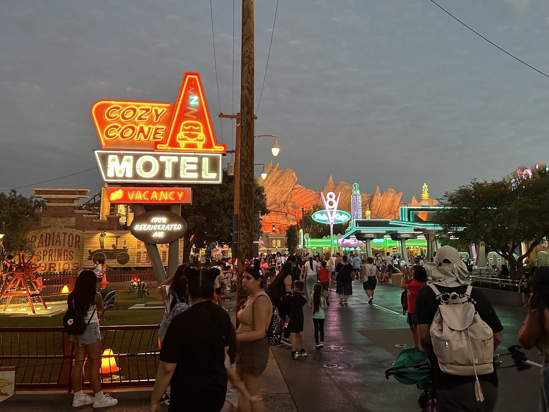Radiator Springs at night. The Cozy Cone Motel and Flo’s V8 cafe neon glow against the night sky.