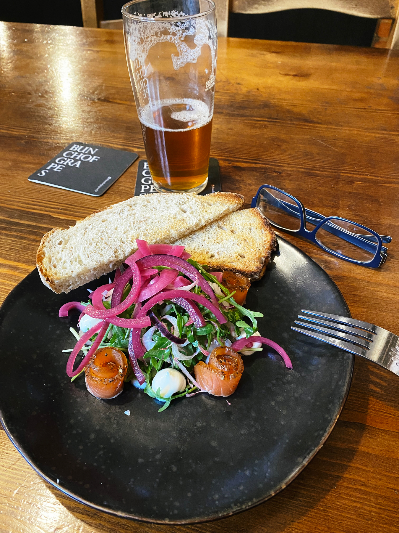 Plate of cured salmon with salad and toasted bread
