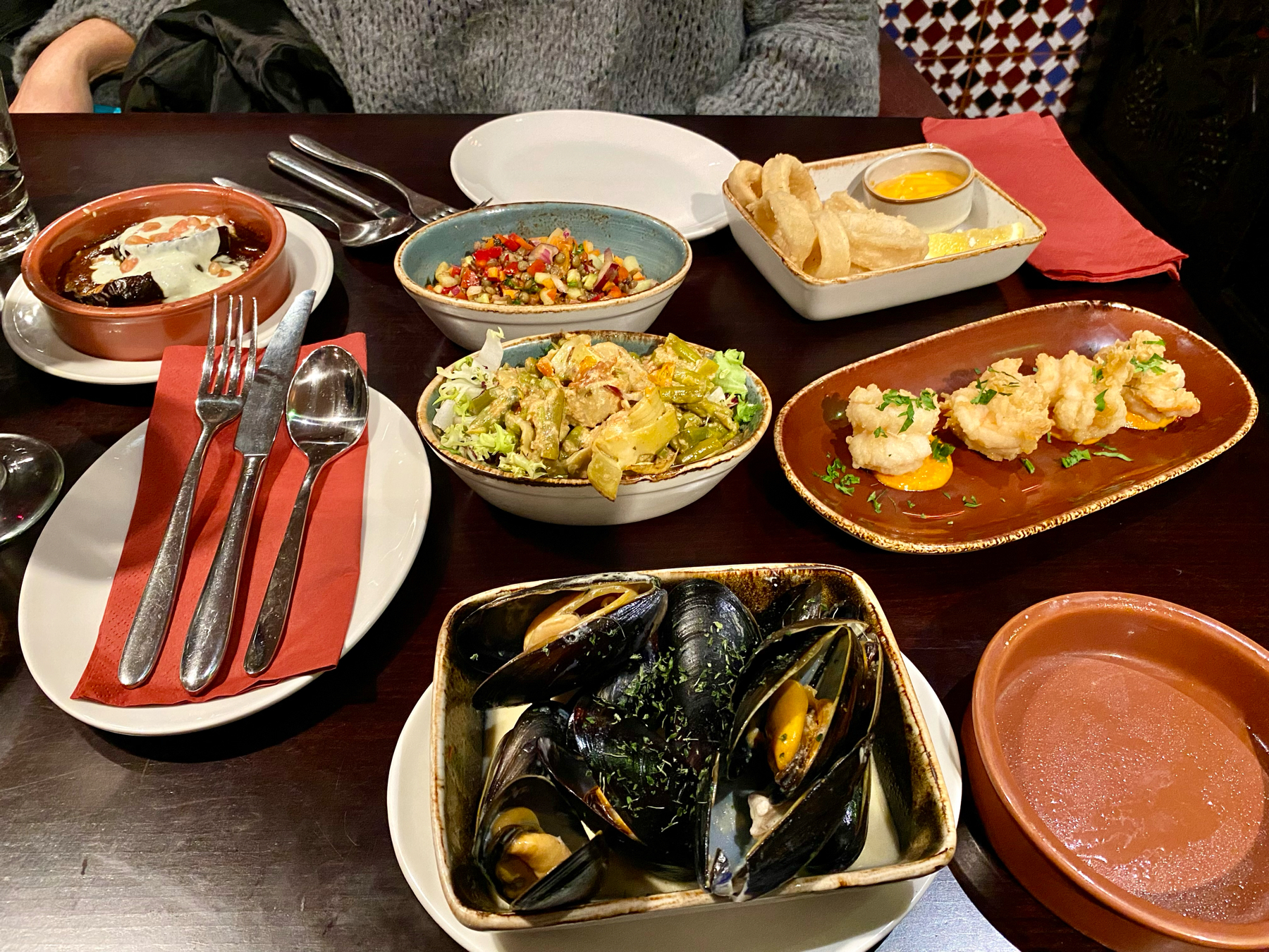 Small plates of food on a table - mussels, prawns, calamari and salads