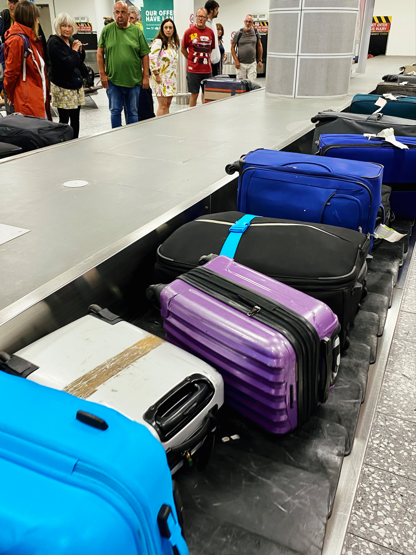 Multicoloured suitcases on an airport luggage conveyor belt
