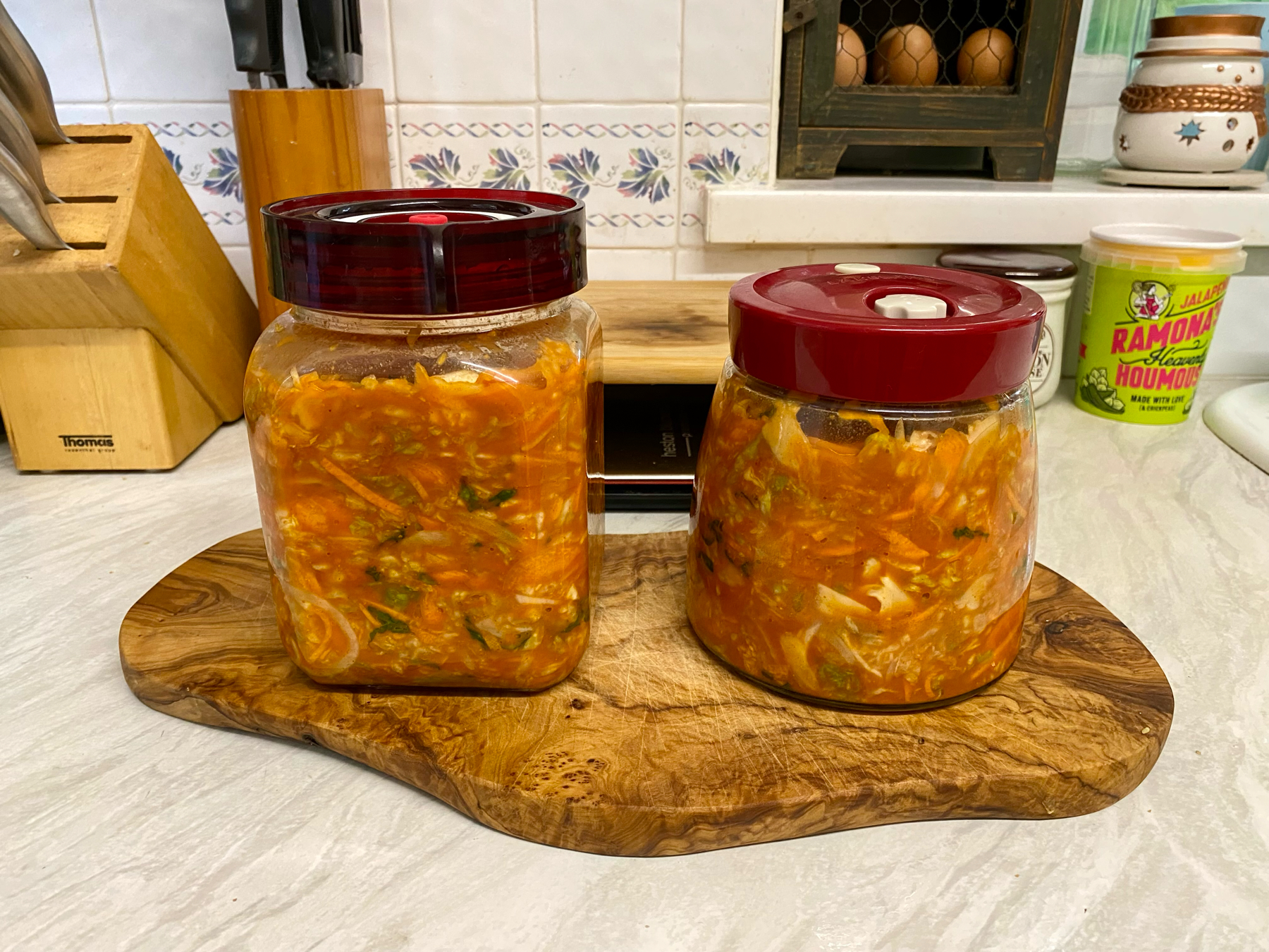 Two sealed jars of finely chopped vegetables in a reddish brown liquid
