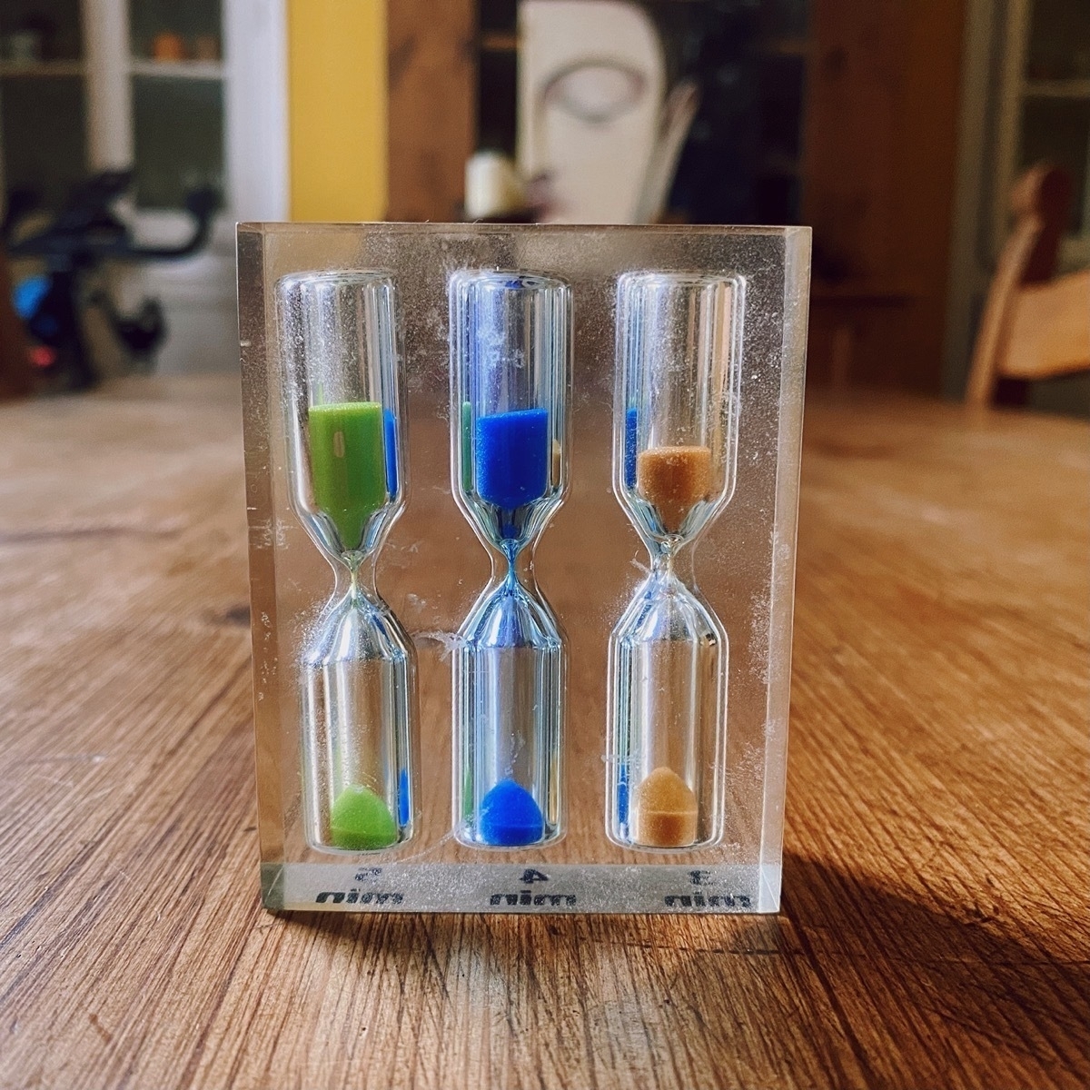 Close up of triple hourglass sand timer with three different colours of sand