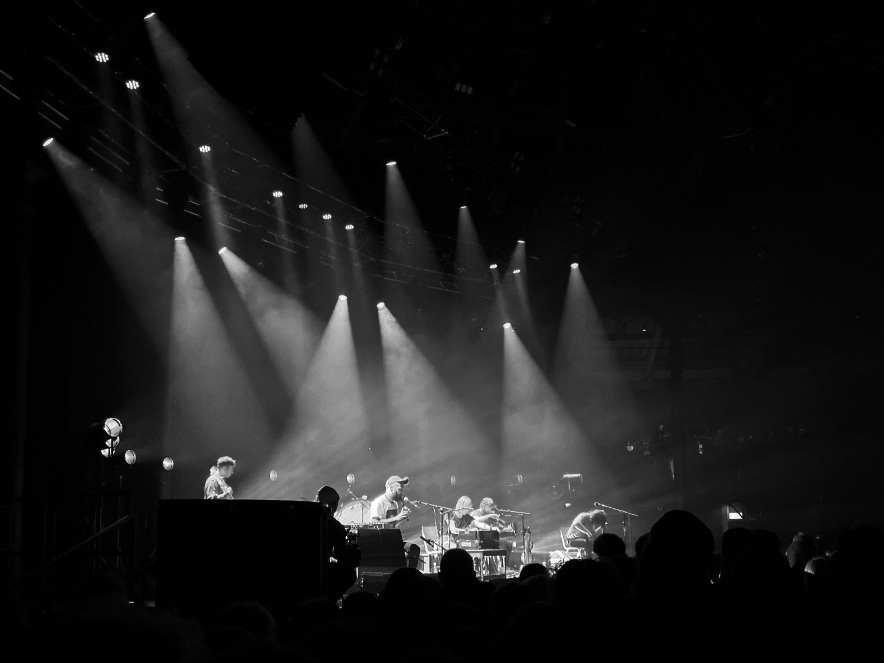 Monochrome image of musicians on stage under strong lighting