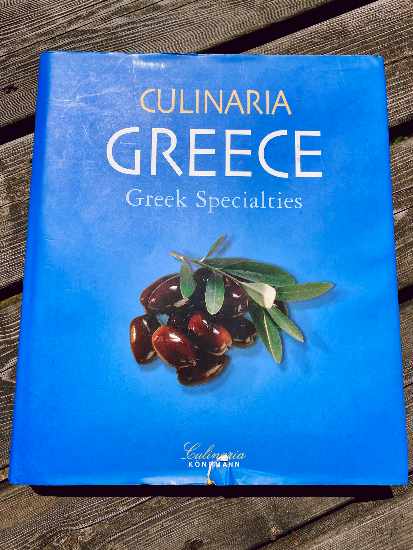 Cover of Greek cookery books. Olives and olive leaves on a vibrant blue background