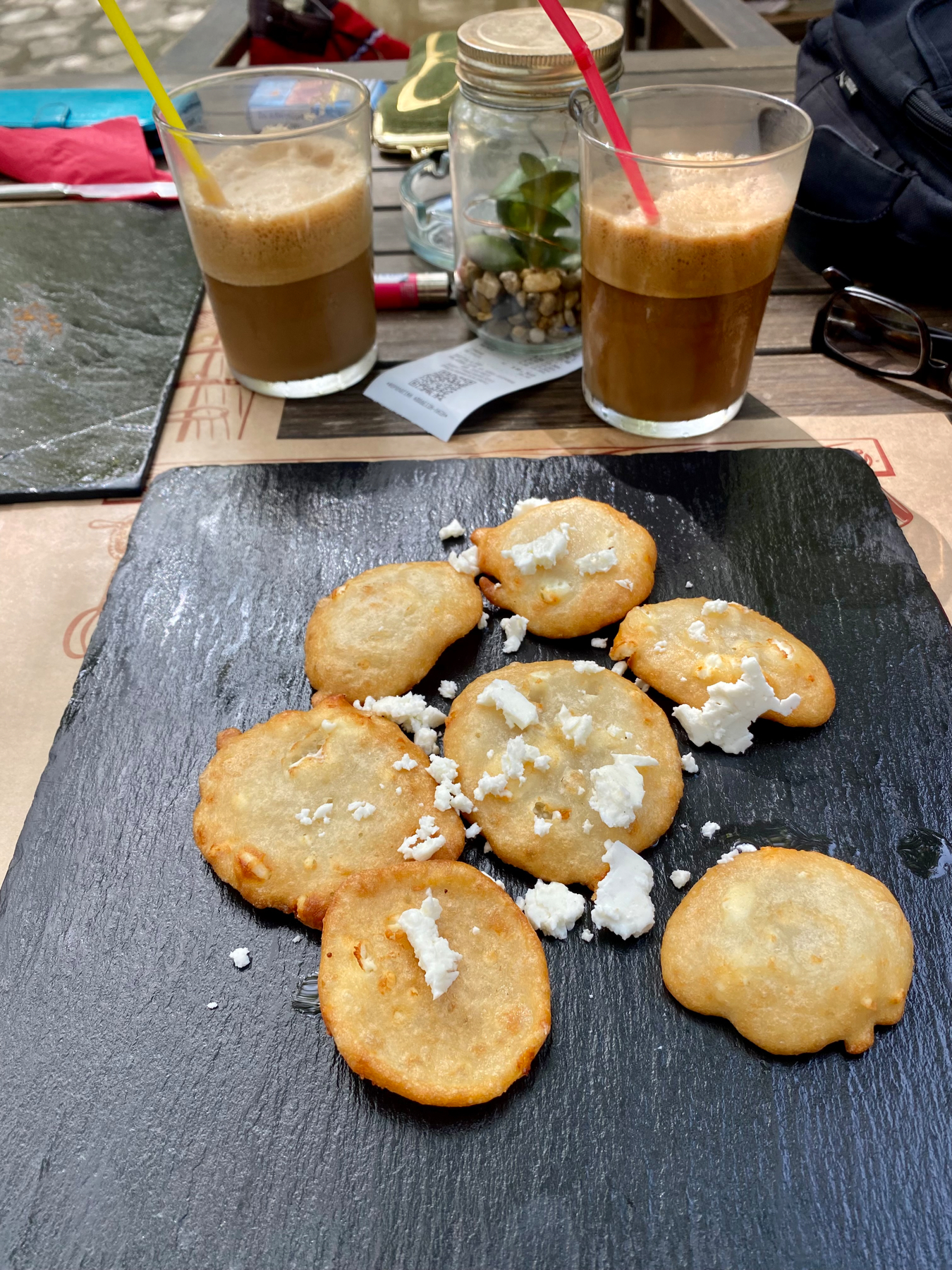 Small pancakes topped with feta cheese on a slate tile 