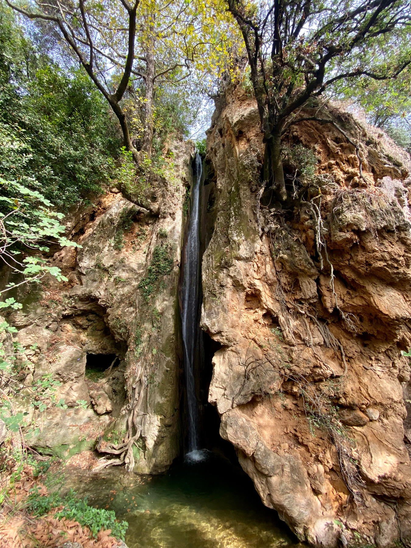 Narrow waterfall cascading down a small rocky cliff