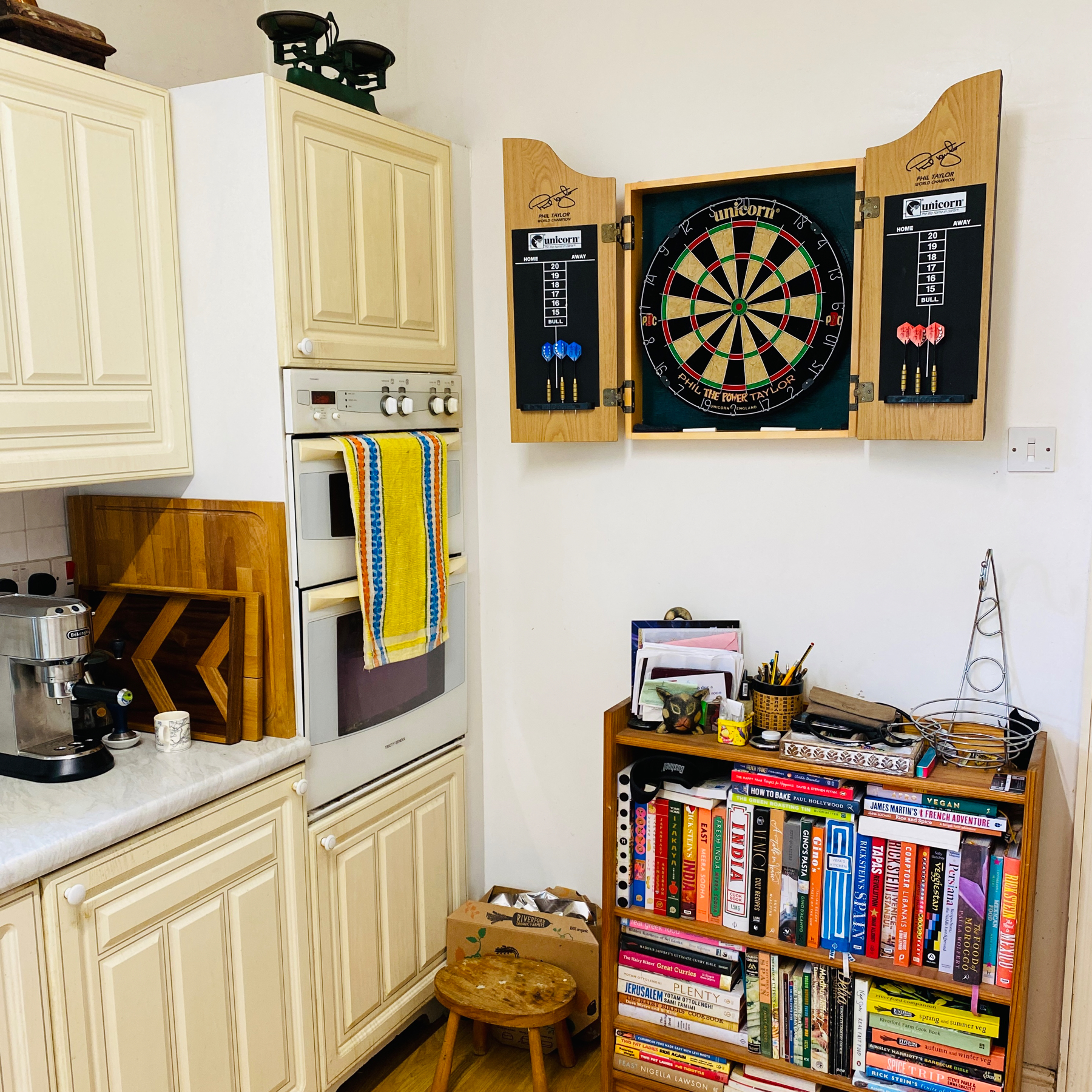 Dartboard mounted on a kitchen wall adjacent to the oven