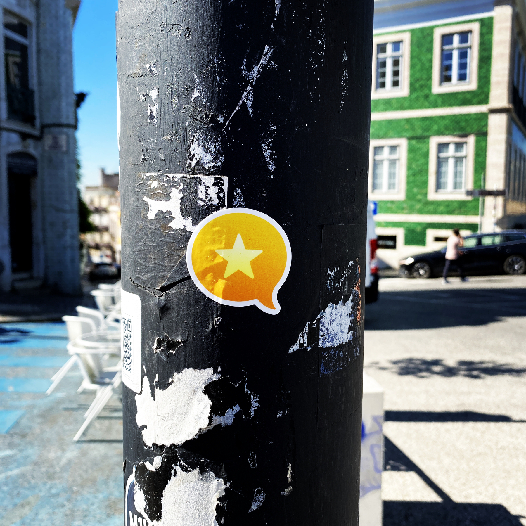 Orange sticker with yellow star on a city lampost