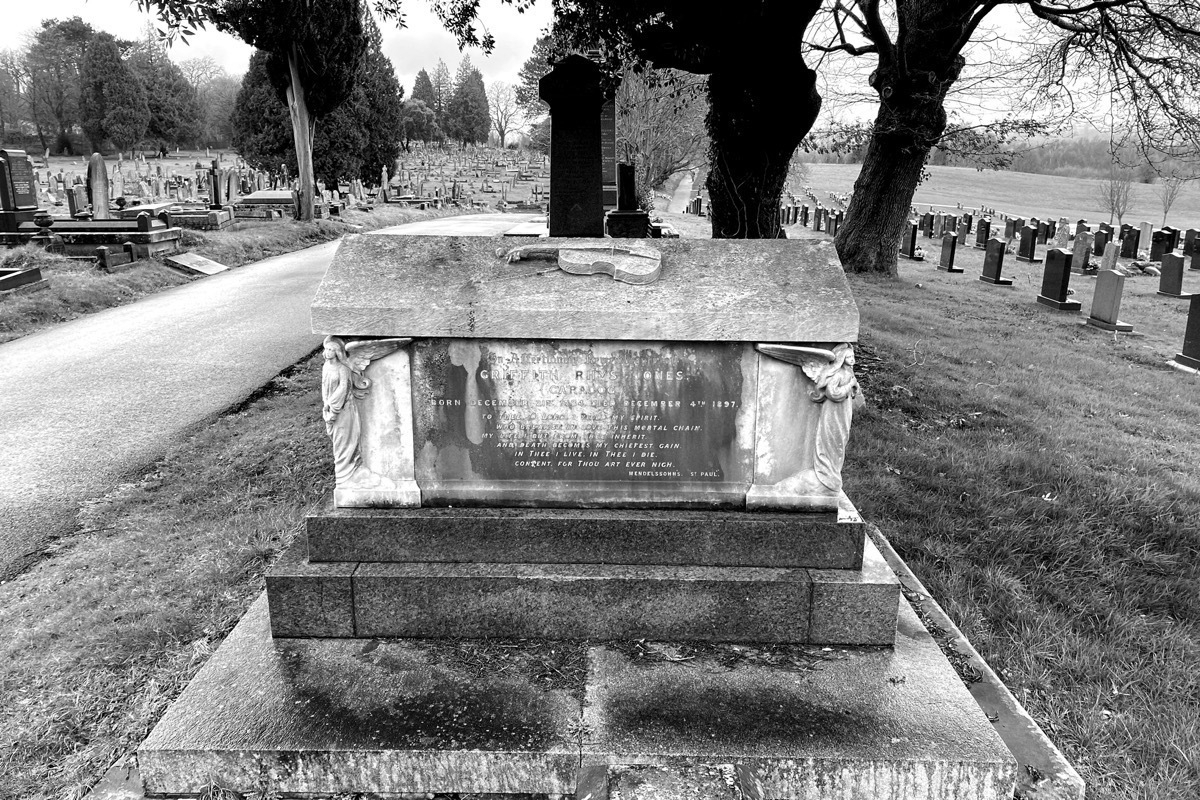 Graveyard, tombstone of Caradog with carved violin on the top, monochrome
